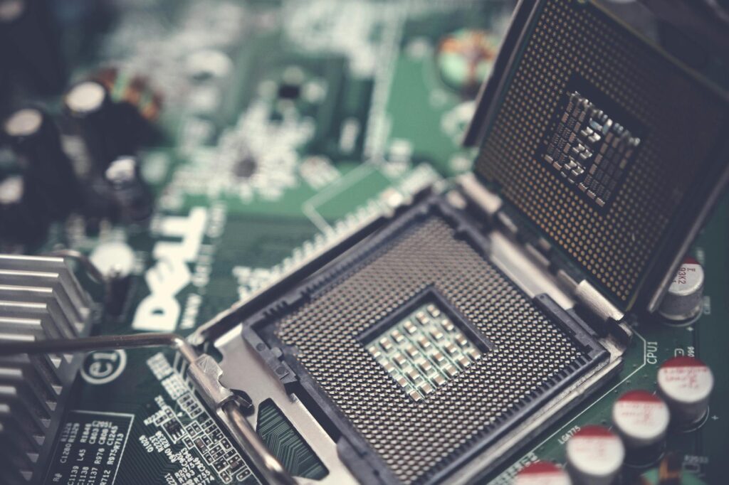 A close-up shot of physical Bitcoin and Ethereum coins glowing on a dark computer motherboard.