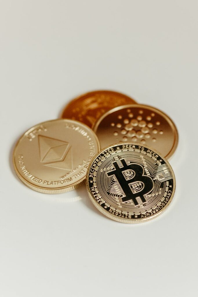 A detailed close-up of a physical Bitcoin coin glowing with a golden light against a dark background.