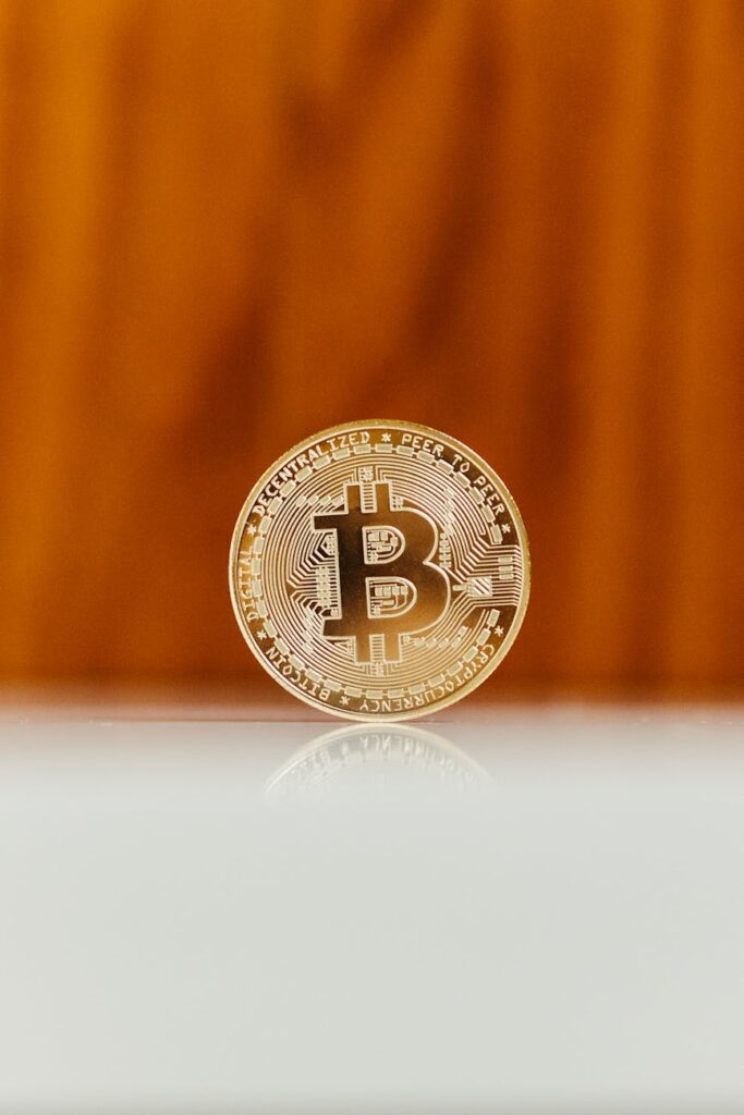 A gold physical Bitcoin coin resting on a stack of US dollar bills, symbolizing the blend of old and new finance.