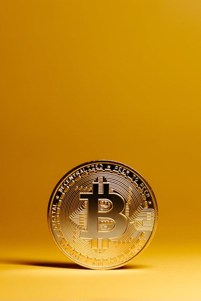 The flag of a nation flying next to a physical Bitcoin, representing the concept of national crypto adoption.
