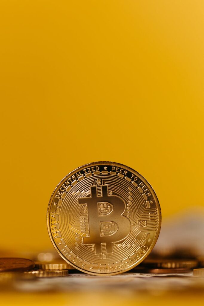 A physical Bitcoin coin sits next to a large, devalued stack of Venezuelan bolivar banknotes, illustrating the concept of hyperinflation.