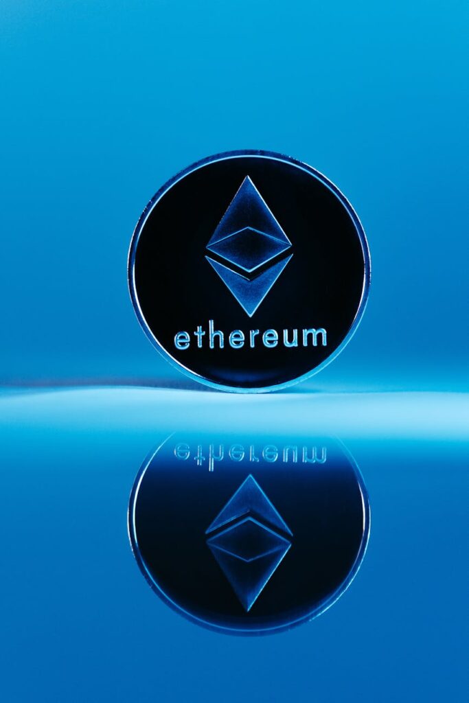 A close-up shot of a physical Ethereum coin glowing against a dark, textured background.