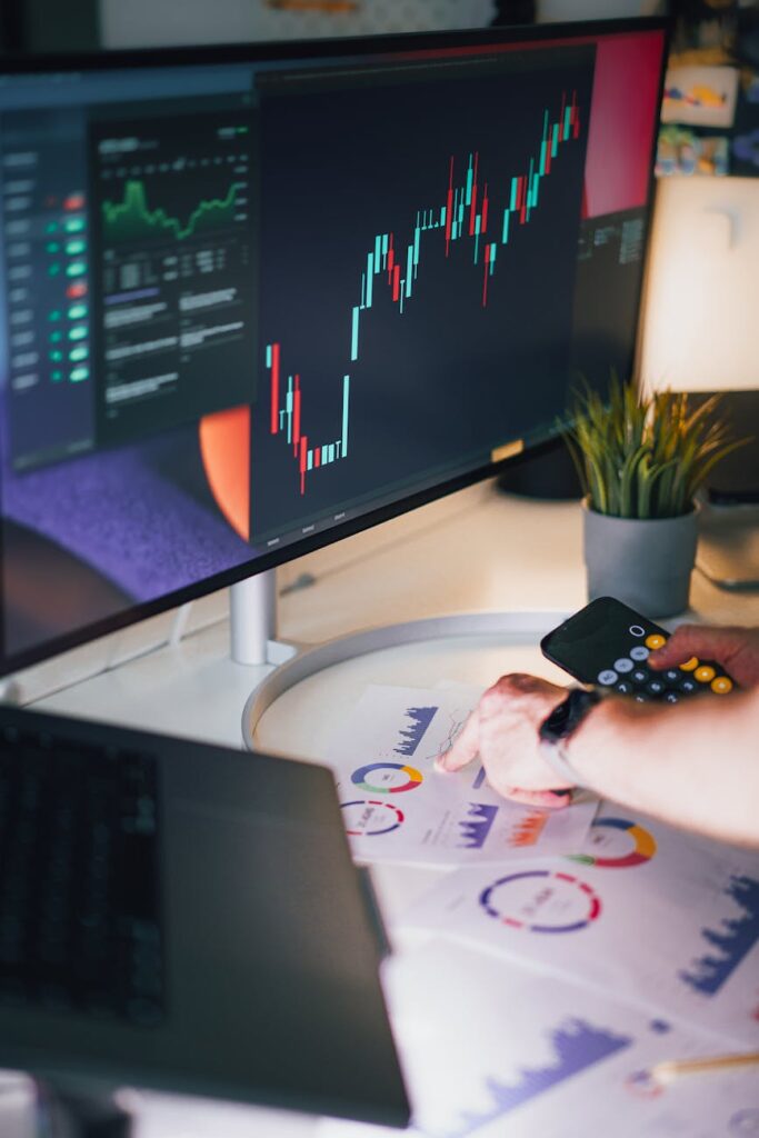 A compliance officer at a desk reviewing cryptocurrency transaction data on a laptop screen for Travel Rule adherence.