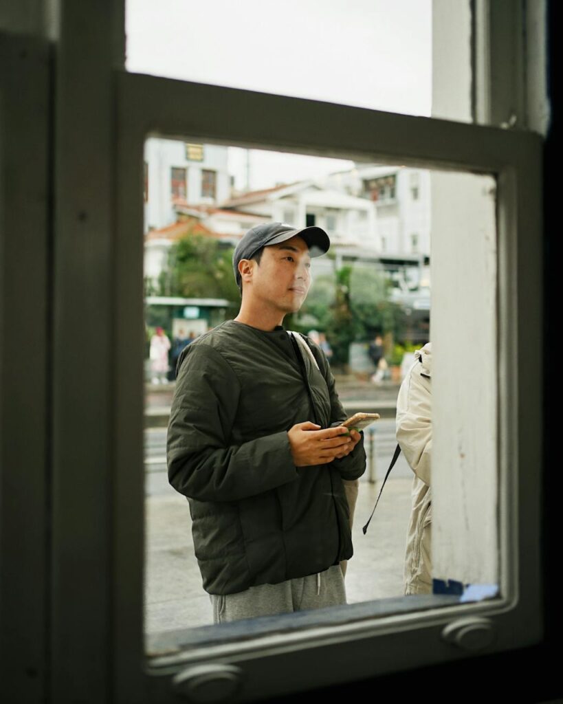 A person holding a smartphone displaying a fluctuating cryptocurrency price chart.