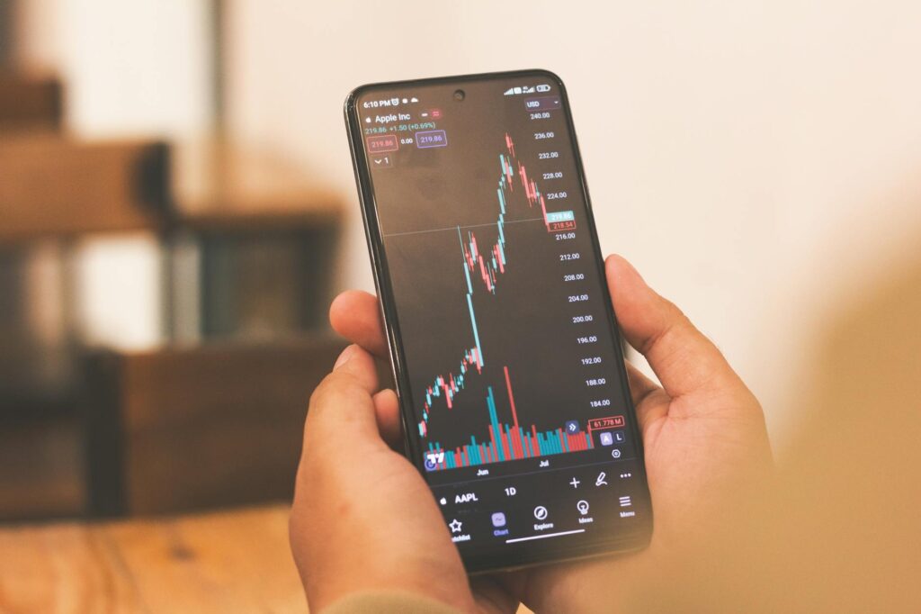 An investor holding their head in frustration while looking at a red, declining financial chart on a computer monitor.