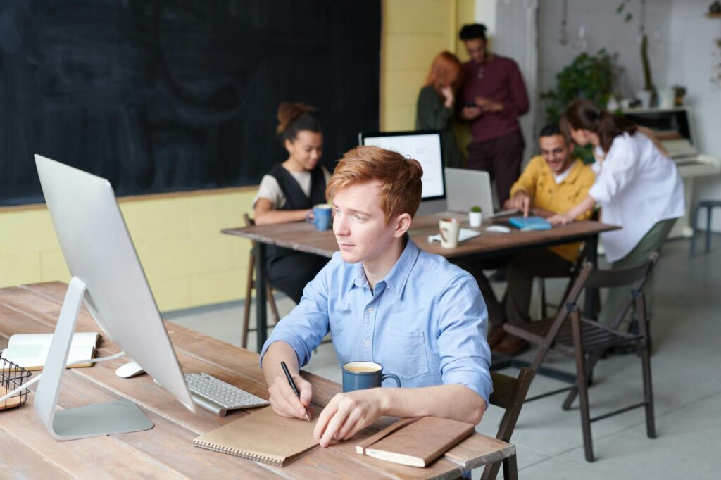 A group of diverse individuals working together around a table, symbolizing community and collaboration.