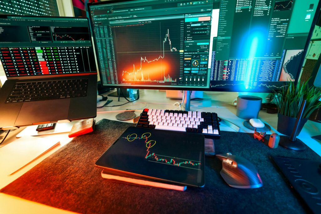 A financial analyst pointing at a complex cryptocurrency candlestick chart on a large monitor.