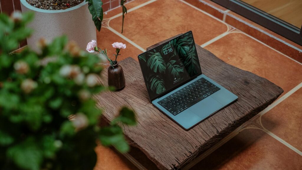 A single physical Bitcoin coin resting on a sleek, minimalist desk next to a laptop, representing digital investment.
