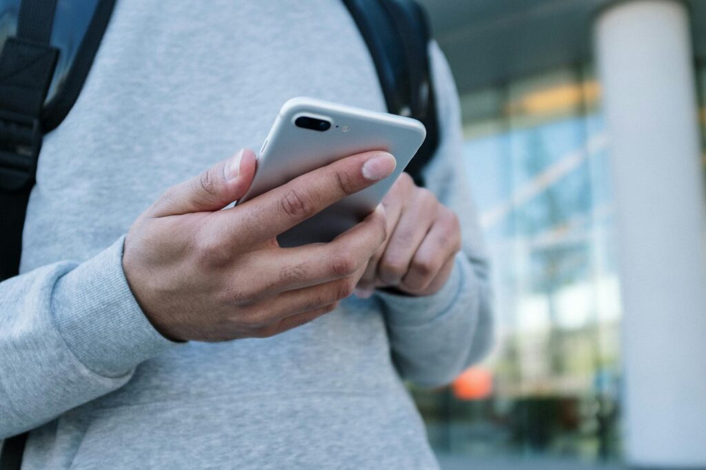 A person's hands holding a smartphone with a cryptocurrency exchange app open, about to confirm a trade.