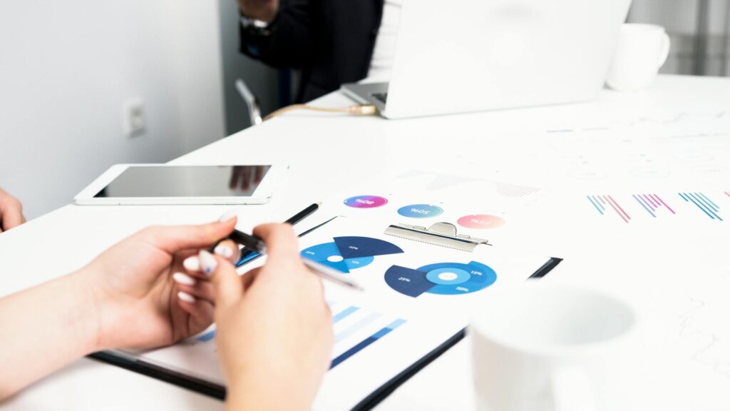 An investor with their head in their hands, looking at complex financial data on a monitor, illustrating market stress.