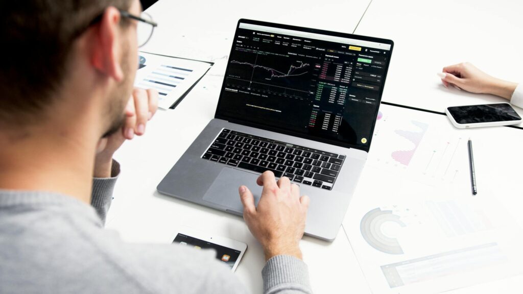 A focused analyst studying complex cryptocurrency charts and data in a dimly lit office.