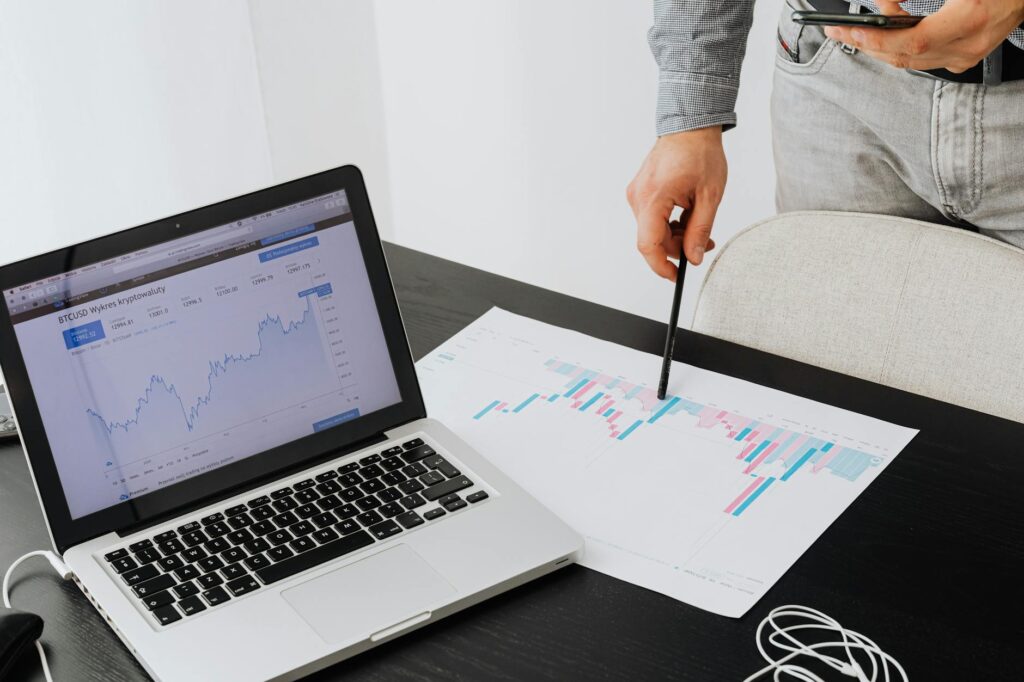 A close-up of a laptop screen displaying a colorful cryptocurrency portfolio analysis with charts and graphs.