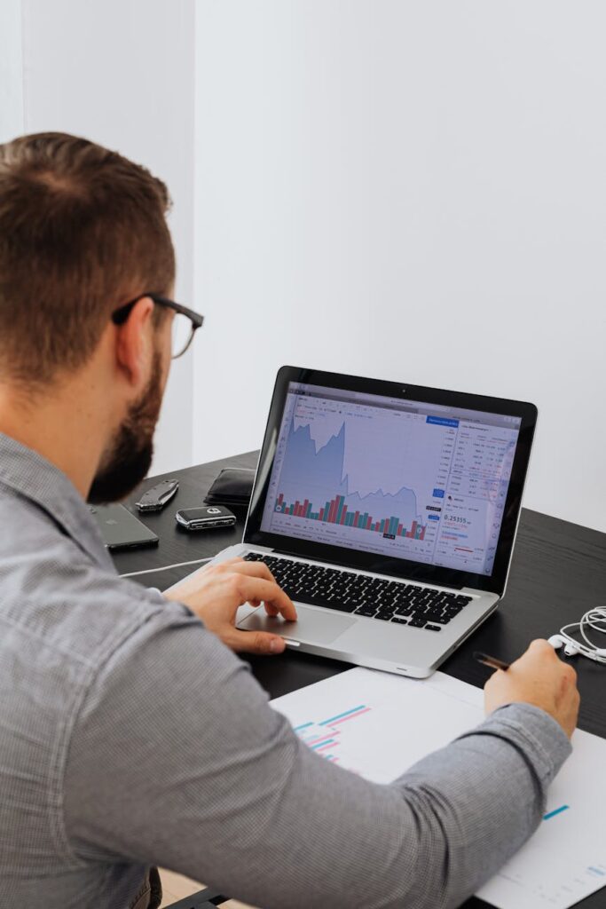 A laptop screen showing a colorful and detailed cryptocurrency portfolio tracking dashboard with various coins and charts.