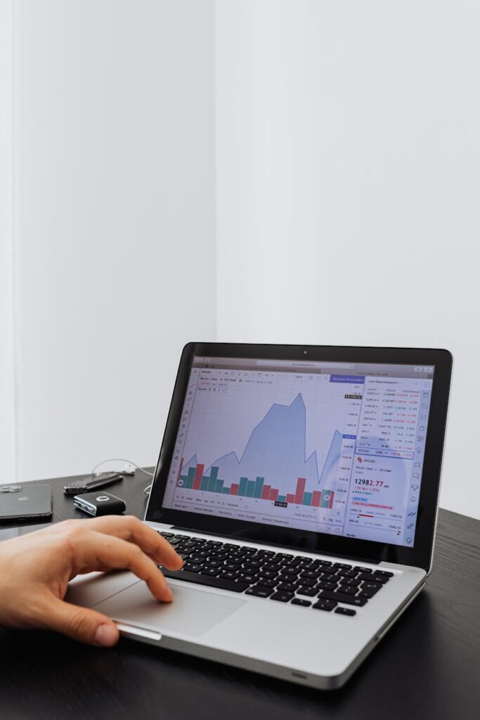 An investor carefully studying complex cryptocurrency price charts on a brightly lit monitor.