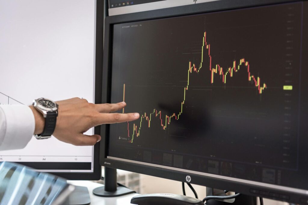 A trader in a dark room looking intently at cryptocurrency price charts displayed on multiple computer screens.