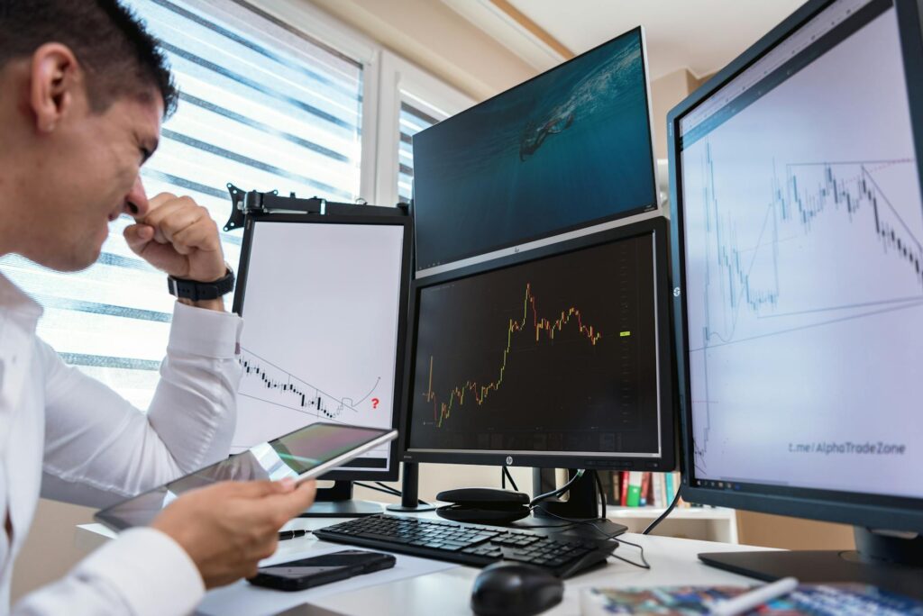 A focused trader analyzing complex cryptocurrency charts on a multi-monitor setup in a dark room.