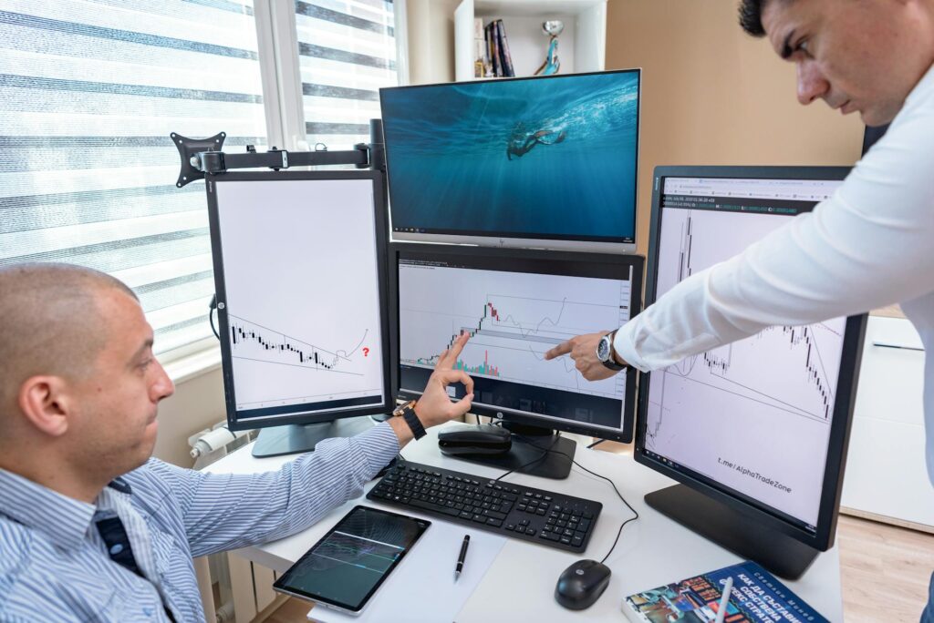 A close-up shot of an investor analyzing complex cryptocurrency price charts on a brightly lit monitor.