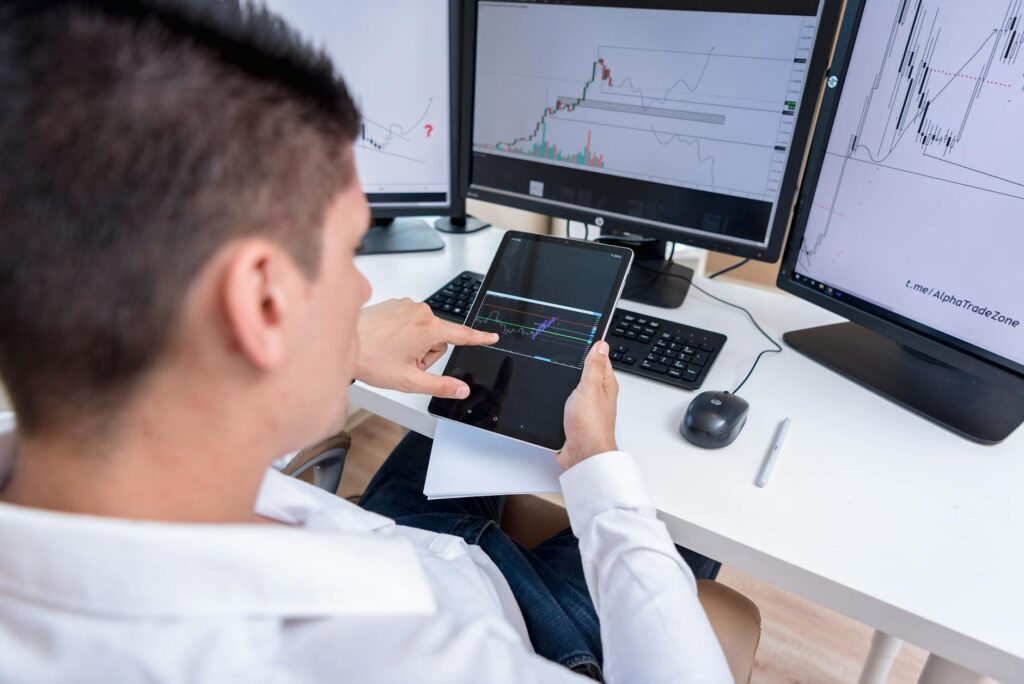 An investor analyzing complex cryptocurrency charts and data on a multi-screen setup.