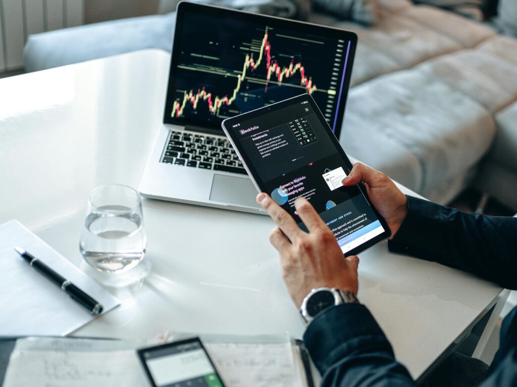 A person focused on a laptop screen displaying complex cryptocurrency price charts and graphs for retirement planning.