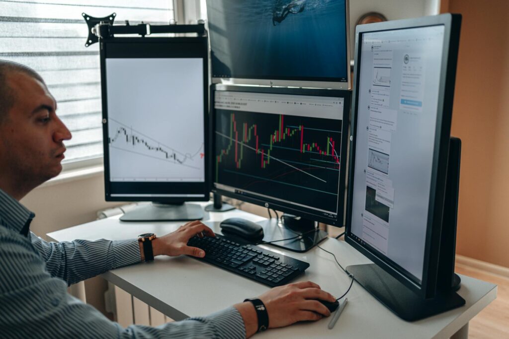 An advanced crypto trader analyzing Bitcoin price charts and data on a multi-monitor setup in a dark room.