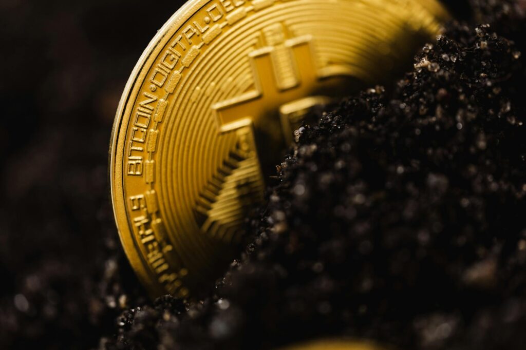 A stack of traditional gold bars placed beside a physical Bitcoin coin, illustrating the concept of digital gold.
