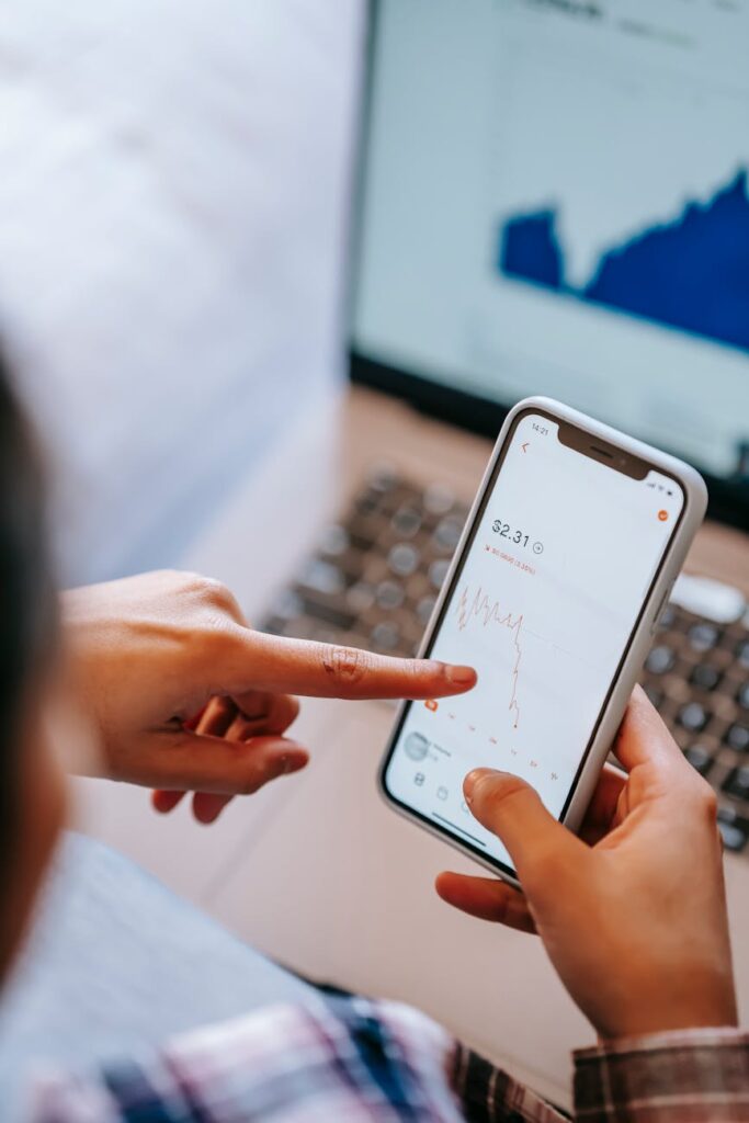 An investor analyzing charts showing cryptocurrency and traditional stock market trends on a computer monitor.