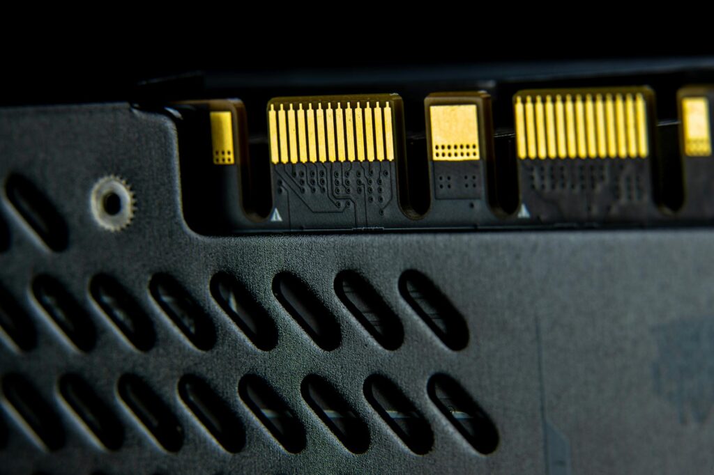 A detailed macro shot of a physical Bitcoin coin resting on a green computer motherboard.