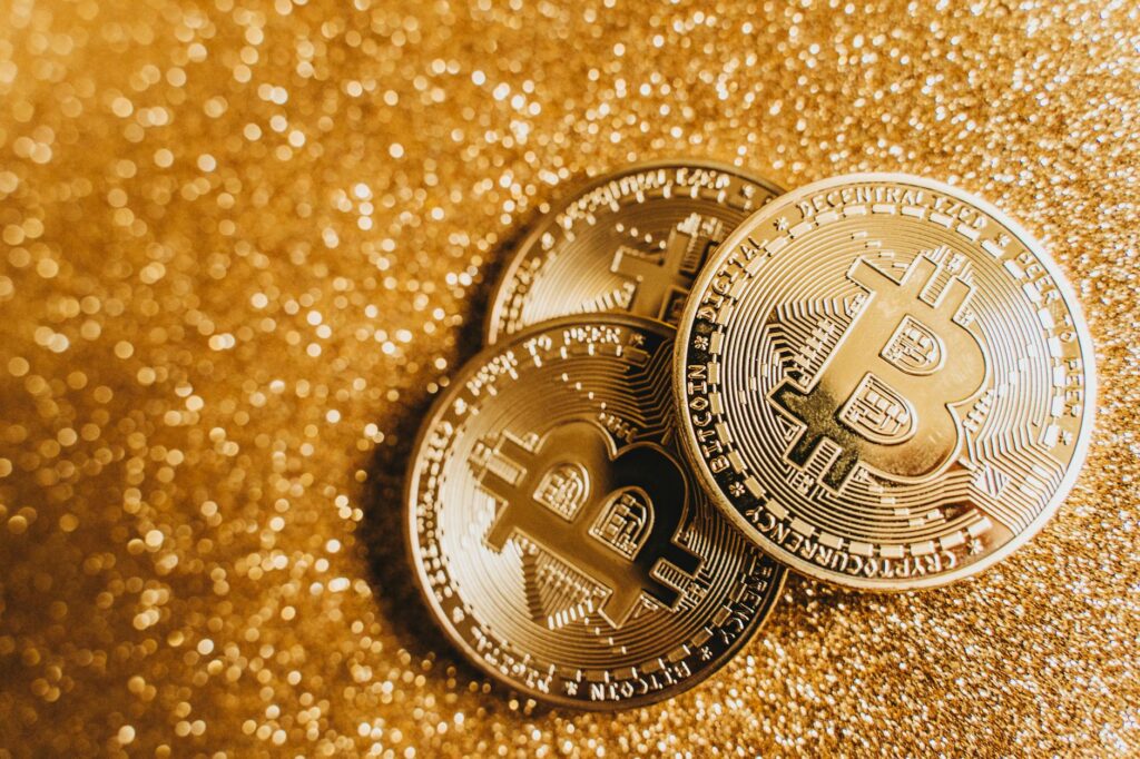Detailed close-up shot of a physical gold Bitcoin on a dark, textured surface, highlighting its investment value.