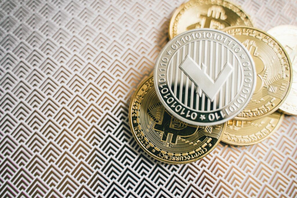 A close-up shot of a physical gold cryptocurrency coin resting on a green computer circuit board.