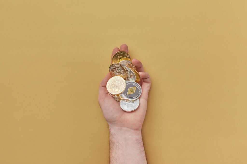 A close-up shot of physical Bitcoin, Ethereum, and other crypto coins, representing the investor capital at stake in DeFi.