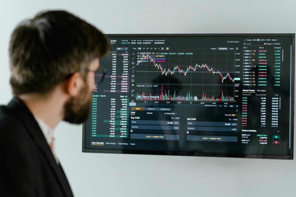 A financial professional analyzing complex cryptocurrency market data on a large monitor in a modern office.
