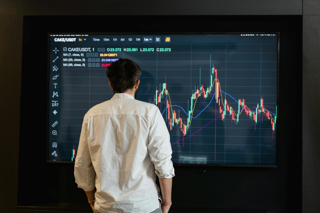 A trader's desk with multiple monitors displaying complex cryptocurrency price charts and data.