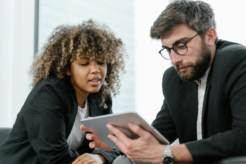 An investor thoughtfully reviewing cryptocurrency market charts on a tablet in a modern office.