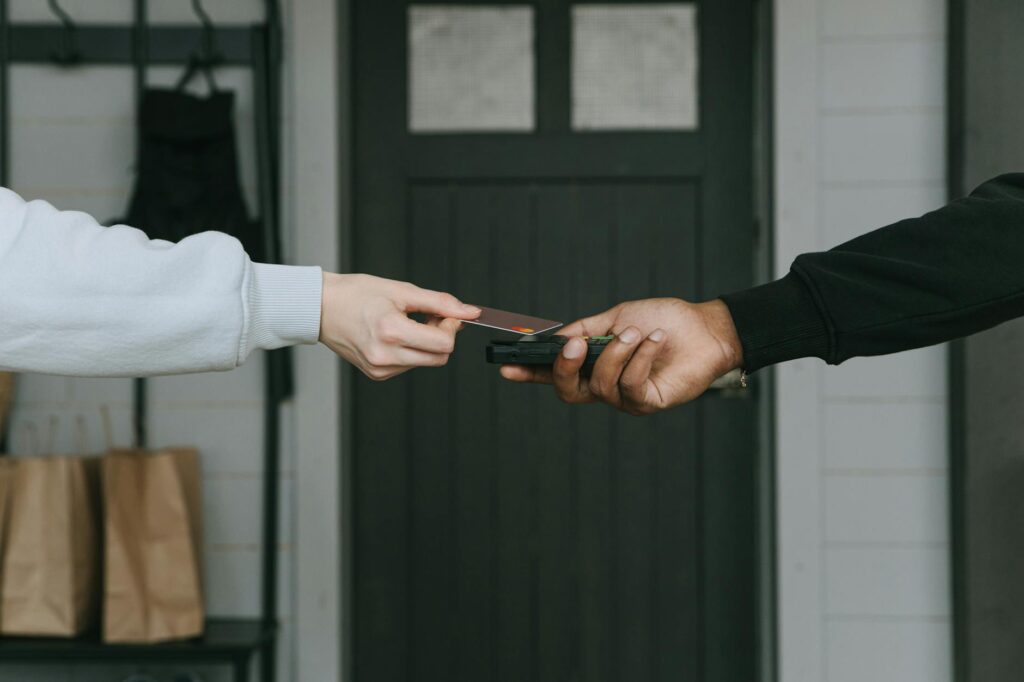 A close-up shot of a hand holding a credit card next to a laptop, symbolizing a secure online transaction for buying cryptocurrency.