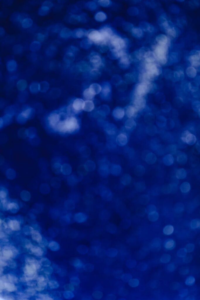 A stylized, glowing physical Bitcoin coin in the foreground with a blurred, futuristic background of digital data streams.