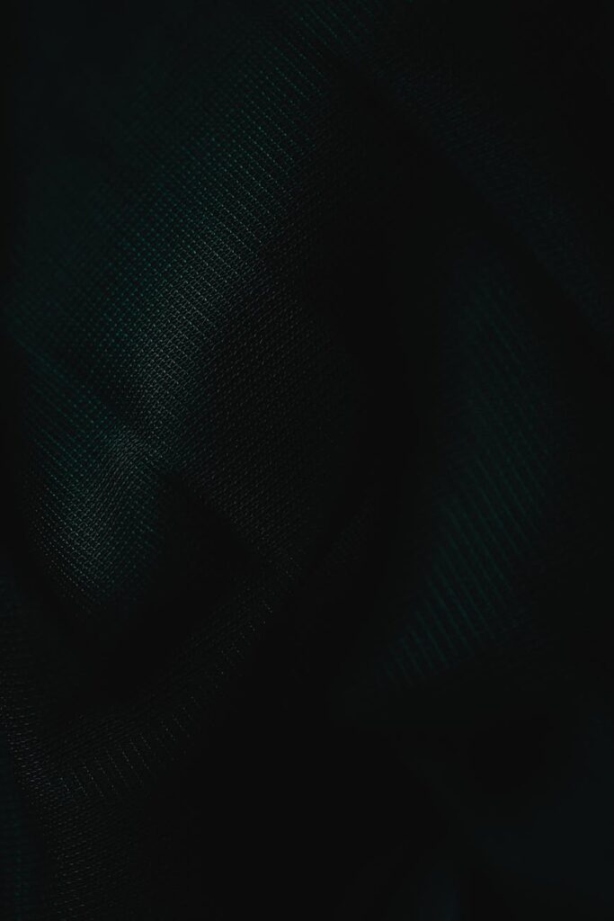 A detailed macro shot of a physical Bitcoin token resting on a textured, dark surface.