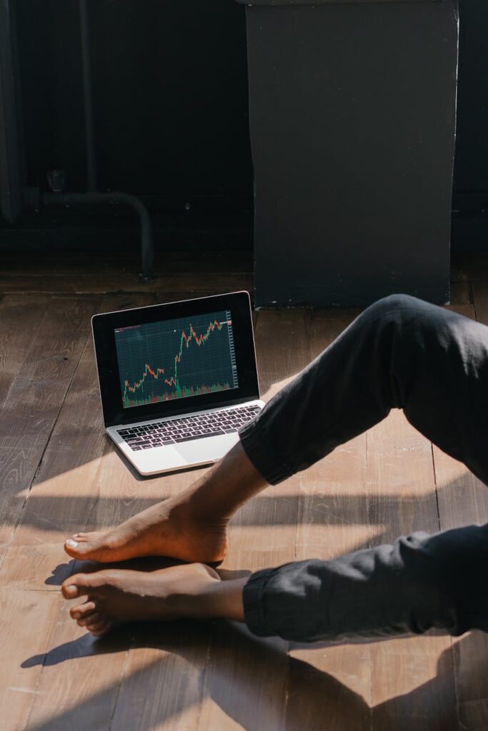 A concerned investor checking volatile Bitcoin price charts on their smartphone in a dark room.