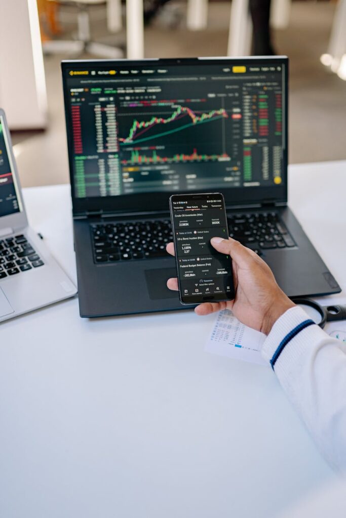 A trader's desk with multiple monitors displaying complex candlestick charts and financial data for cryptocurrency analysis.