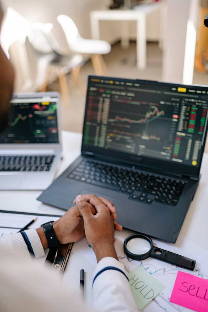 A focused trader's hands on a keyboard, with complex cryptocurrency price charts displayed on multiple monitors in the background.