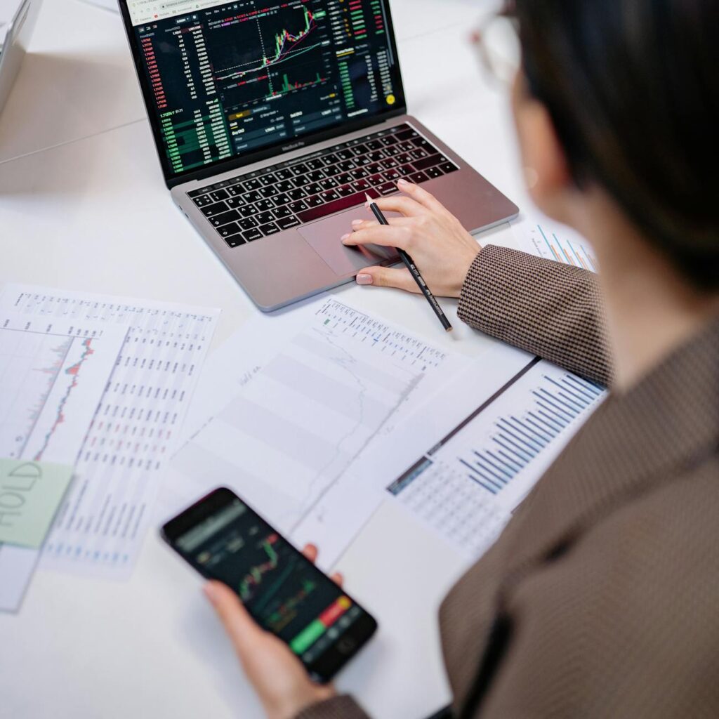 An investor studying a complex cryptocurrency price chart on a multi-monitor setup.