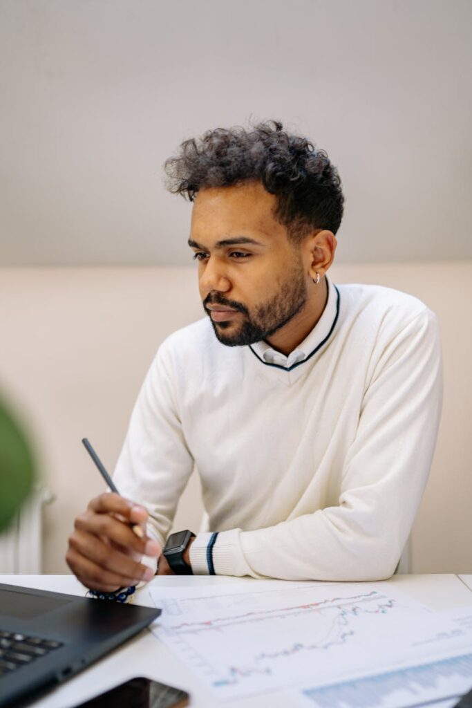 A trader in a dimly lit room looking intently at multiple monitors displaying complex cryptocurrency price charts and data.