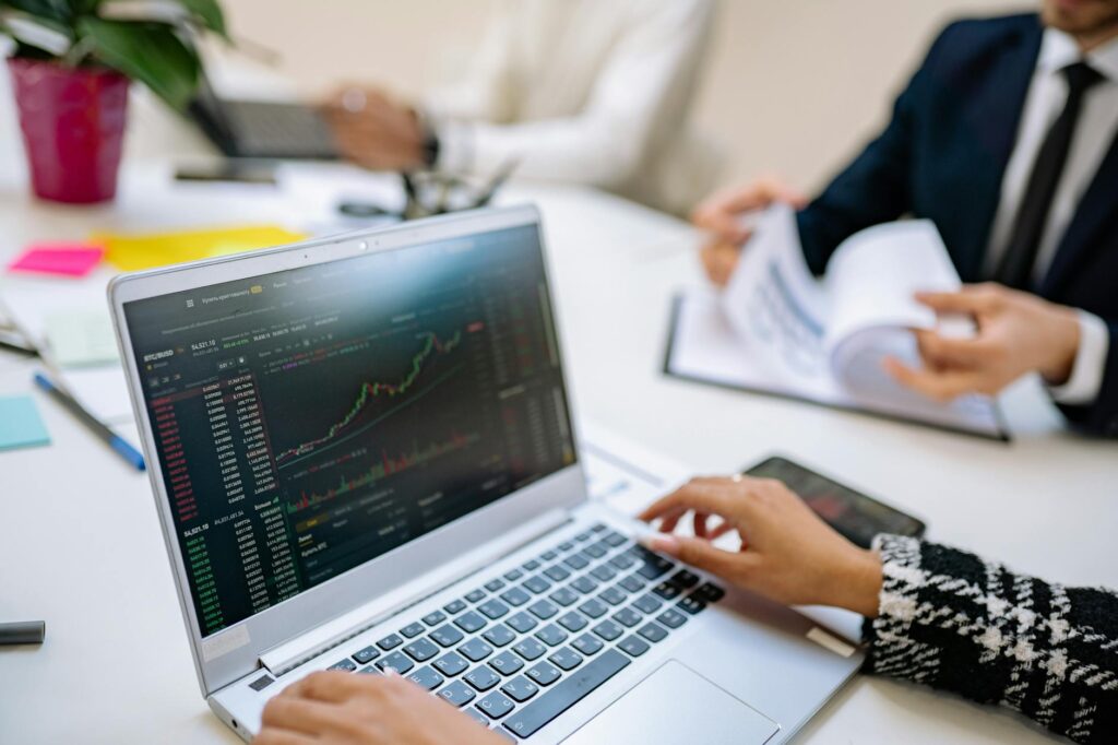 A focused individual analyzing complex cryptocurrency price charts and data on a modern laptop.