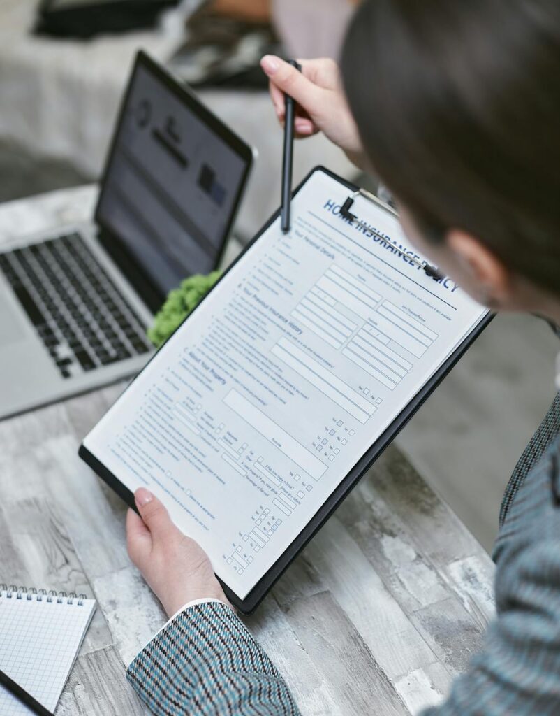 A close-up of a person's hands using a laptop to schedule a recurring cryptocurrency purchase.