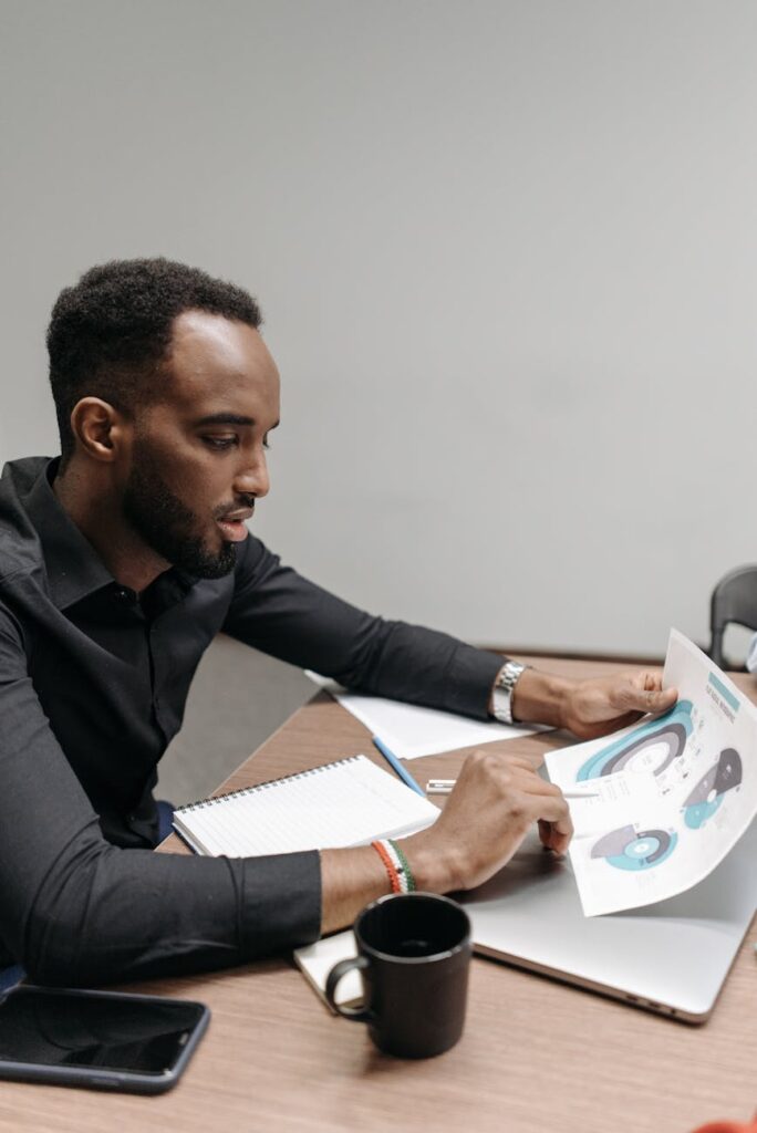 A person's focused face illuminated by a computer screen showing volatile cryptocurrency charts and data.