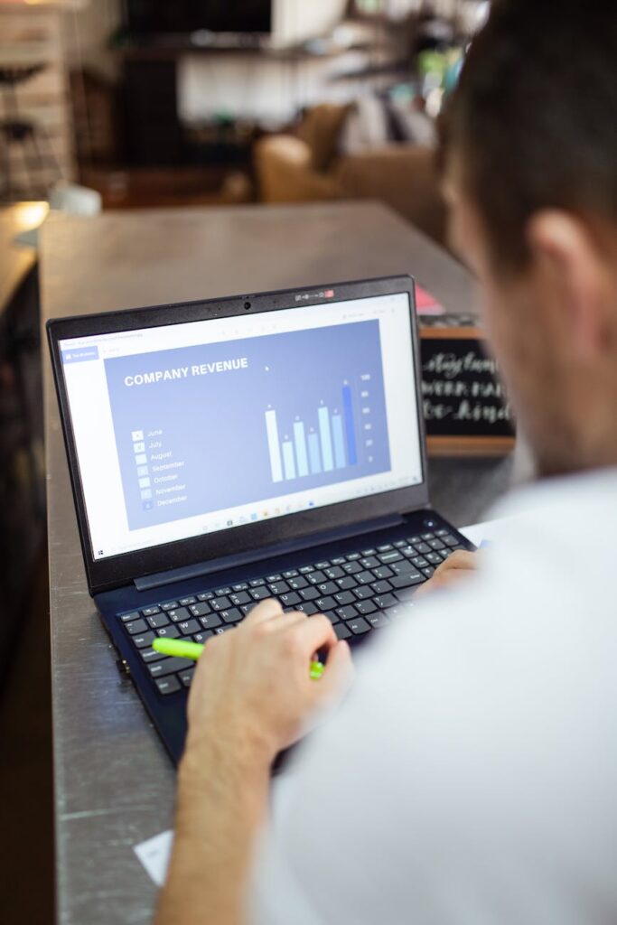 An investor carefully studying complex cryptocurrency price charts on a glowing monitor in a dimly lit room.