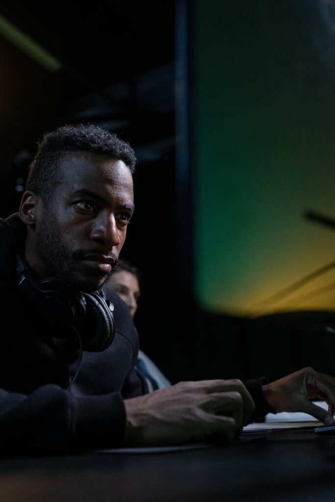 A concerned individual analyzing volatile cryptocurrency charts on a computer screen in a dark room.