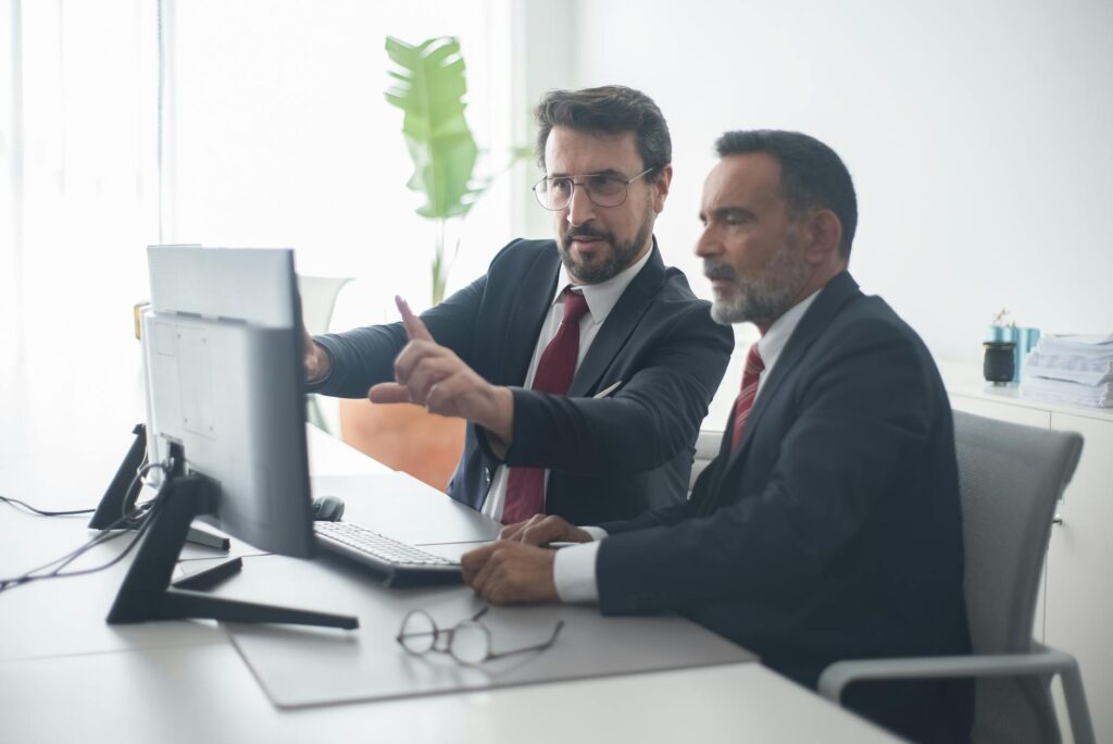 An investor carefully studying complex cryptocurrency price charts and data on a brightly lit computer screen.