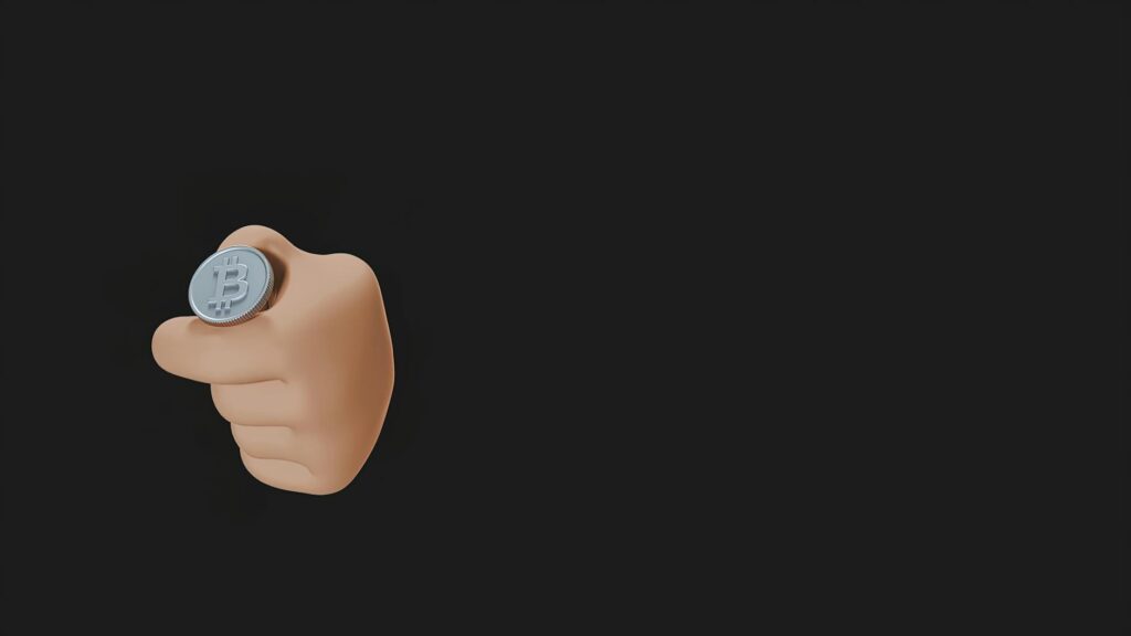 A close-up shot of a physical gold Bitcoin token resting on a textured black surface.