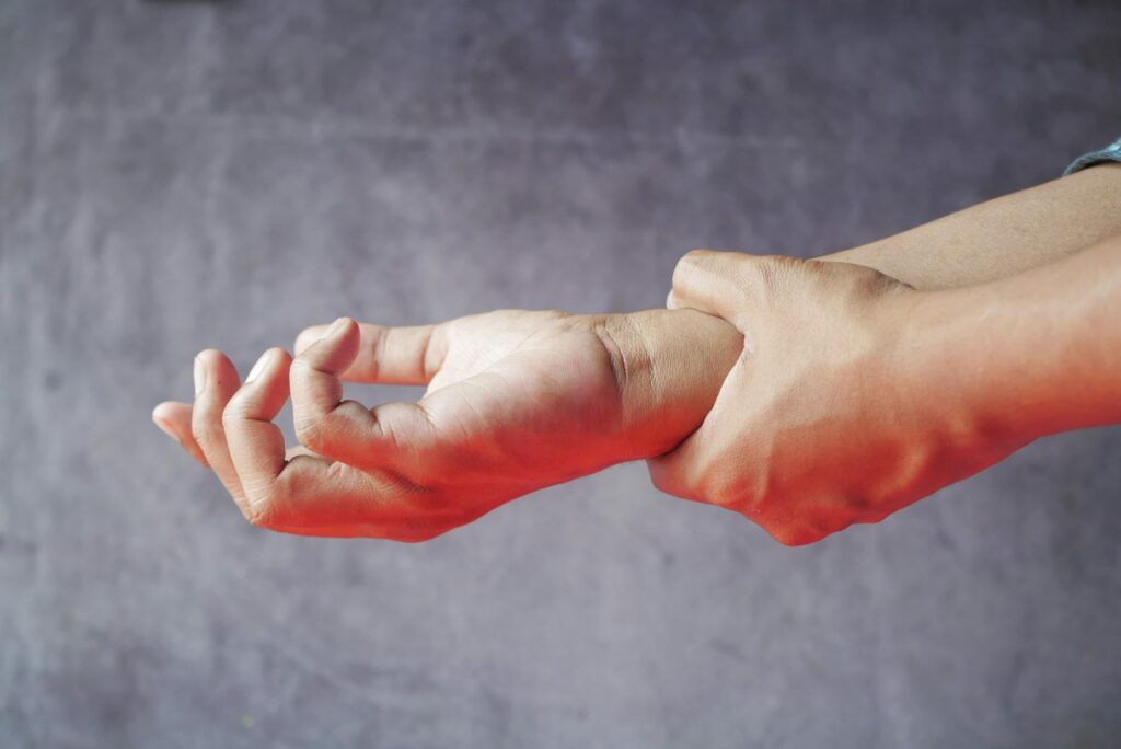 A close-up shot of a person's hand holding a single, shiny gold physical bitcoin, symbolizing digital value.