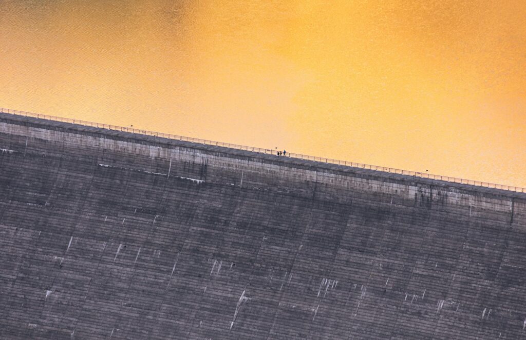 A massive hydroelectric dam with water powerfully flowing, representing a sustainable energy source for crypto mining.